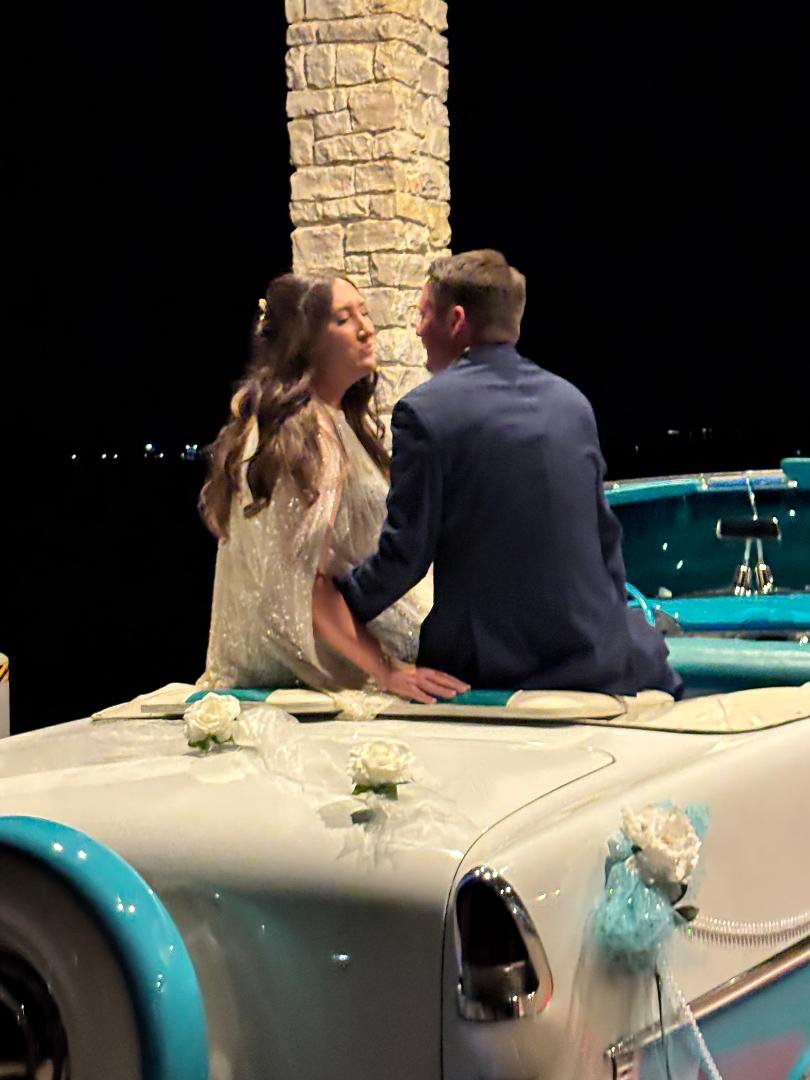 Newlyweds sharing a close moment while seated in Ole' Belle