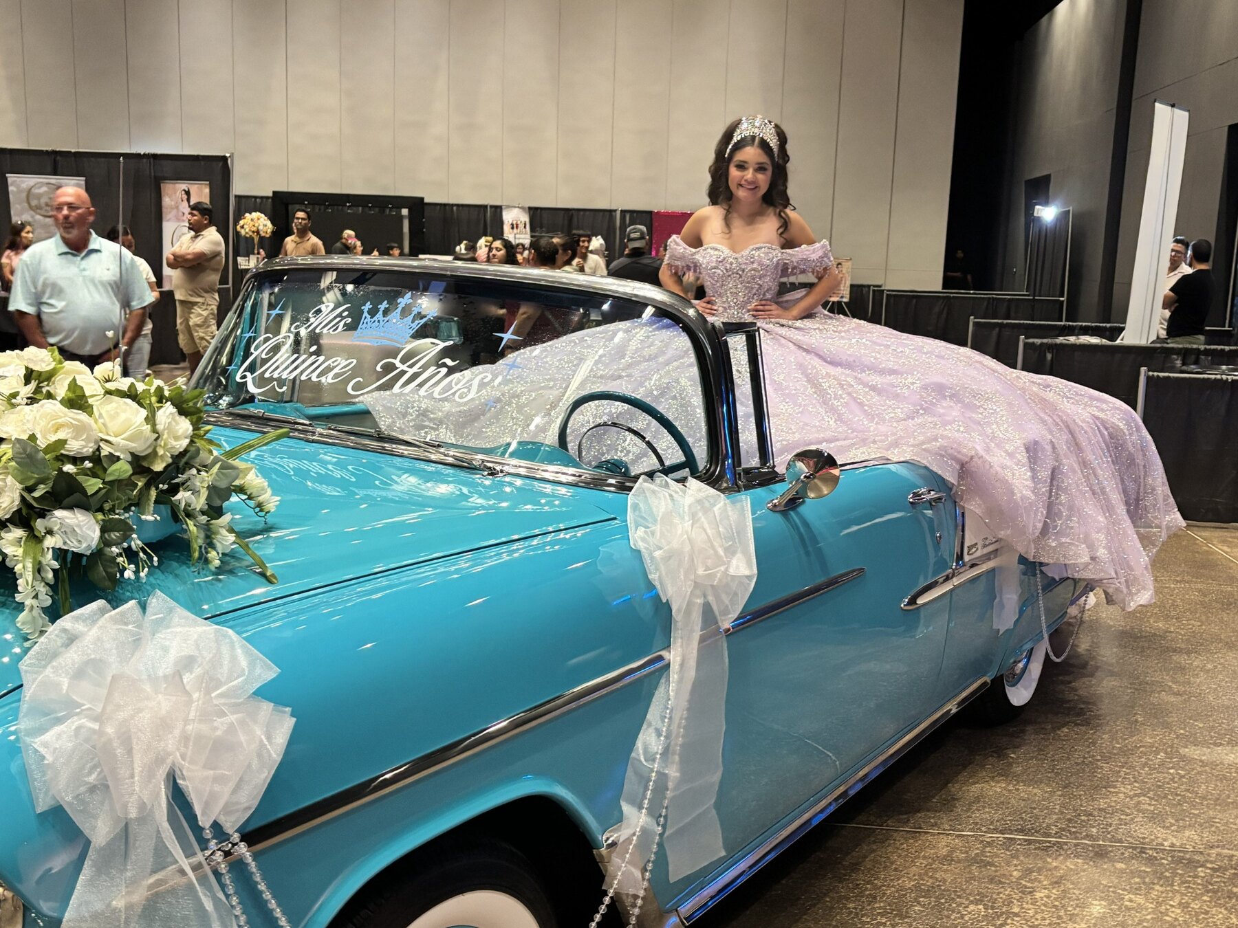 Young woman in a lavender quinceañera gown posing beside the windshield of Ole' Belle